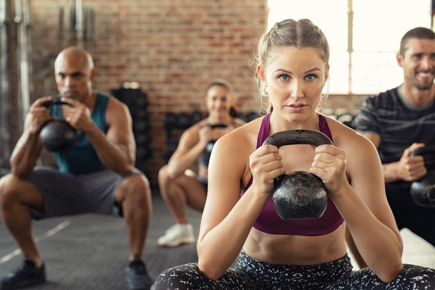 Groupe en plein entraînement de fitness avec kettlebells